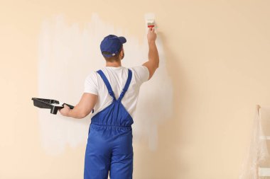 Erkek ressam odada tamirat yapıyor.