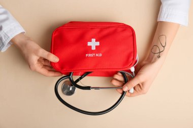 Steteskop ve renk arkaplan üzerine ilk yardım çantası olan doktorun elleri