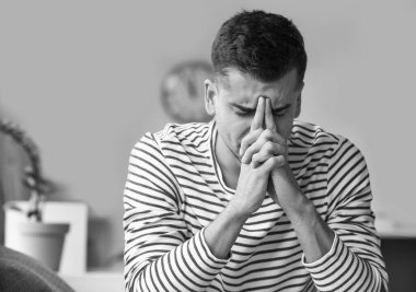 Evdeki depresif genç adamın siyah beyaz portresi