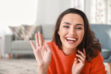 Genç bir kadının evde görüntülü konuşması.