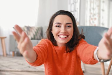 Genç bir kadının evde görüntülü konuşması.