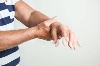 Gri arka planda Parkinson sendromu olan yaşlı bir adam.