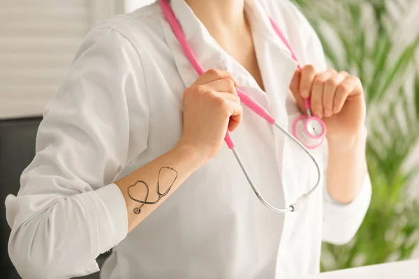 特写时手臂上有听诊器纹身的女医生 — 图库照片