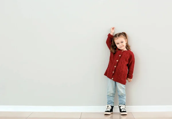 Cute Little Girl Measuring Height Grey Wall — Stock Photo, Image