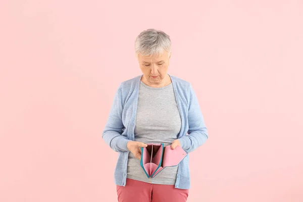 Seniorin Mit Leerem Geldbeutel Auf Farbigem Hintergrund — Stockfoto