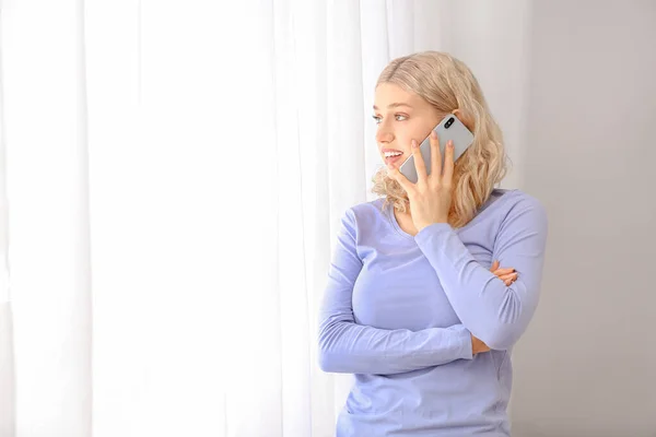 Mujer Joven Hablando Por Teléfono Móvil Cerca Ventana —  Fotos de Stock