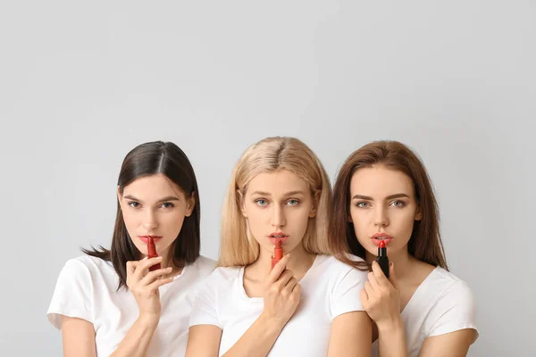 Hermosas Mujeres Jóvenes Aplicando Maquillaje Sobre Fondo Claro — Foto de Stock