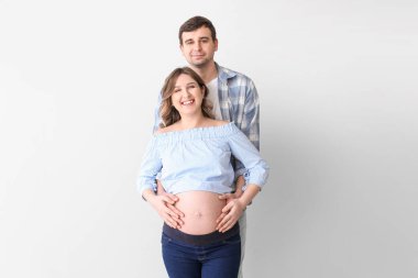 Gri arka planda güzel hamile bir çift