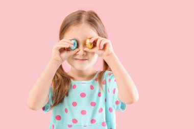 Renkli çikolatalı yumurtaları olan tatlı küçük bir kız.