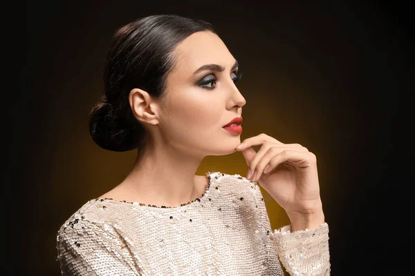 Young woman with beautiful makeup on dark background