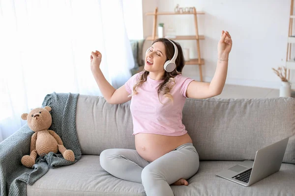 美しい妊娠中の女性は自宅で音楽を聴く — ストック写真