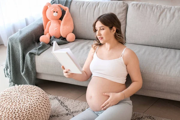 美しいです妊娠中の女性読書本に家 — ストック写真