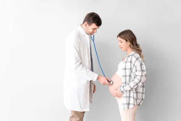 Médico Examinando Mujer Embarazada Contra Fondo Gris — Foto de Stock