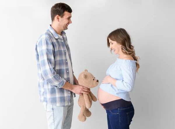 Mooi Zwanger Paar Met Teddybeer Grijze Achtergrond — Stockfoto