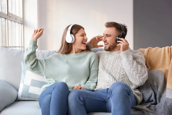 Happy young couple listening to music at home