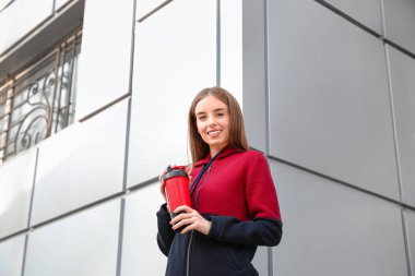 Dışarıda protein içeceği içen genç sporcu kadın.