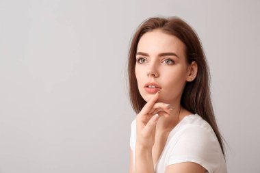 Açık arkaplanda güzel makyajlı genç bir kadın.