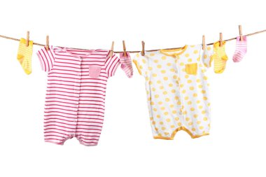 Beyaz arka planda bebek kıyafetleri asılı.