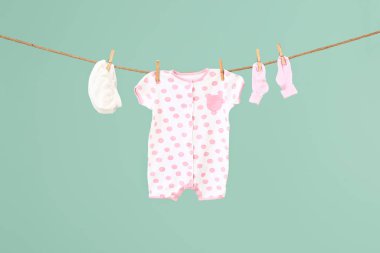 Bebek kıyafetleri renk arkaplanında ipte sallanıyor