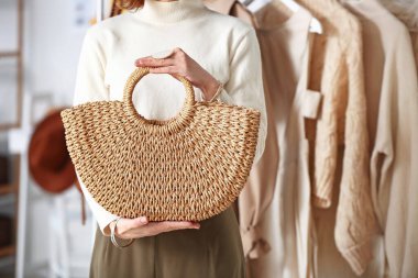 Stüdyosunda çantası olan kadın stilisti.