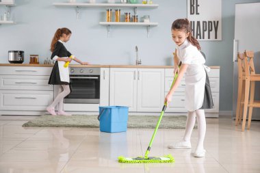 Küçük sevimli oda hizmetçileri mutfağı temizliyor.