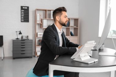 İş adamı ofiste çalışırken spor salonunda oturuyor.