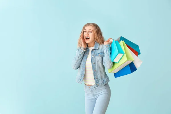 Verrast Jonge Vrouw Met Boodschappentassen Kleur Achtergrond — Stockfoto
