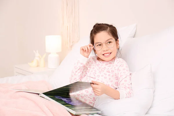 Cute Little Girl Wearing Glasses While Reading Book Bed — Stock Photo, Image