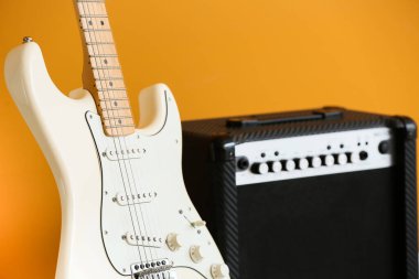Renk arka planında modern gitar ve yükseltici