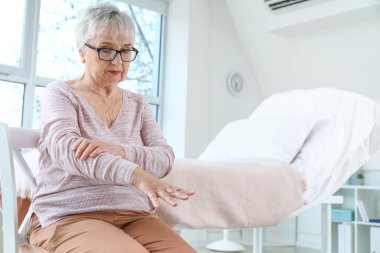 Senior woman suffering from Parkinson syndrome in clinic