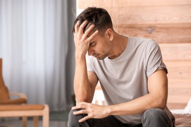 Depresyondaki genç adam yatak odasında