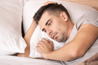 Depresyondaki genç adam yatak odasında