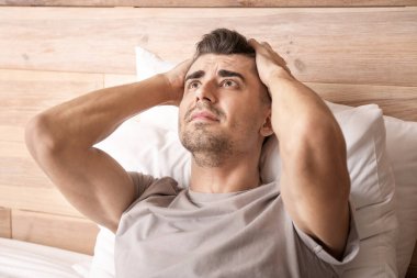 Depresyondaki genç adam yatak odasında