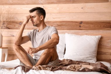 Depresyondaki genç adam yatak odasında