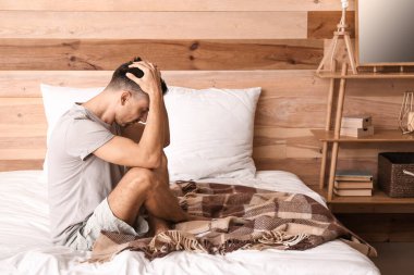 Depresyondaki genç adam yatak odasında