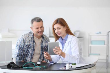 Klinikteki doktoru ziyaret eden olgun bir adam.