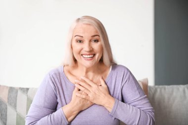 Evde görüntülü konuşma yapan olgun bir kadın