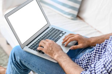 Evde dizüstü bilgisayarda çalışan yakışıklı adam, yakın plan.