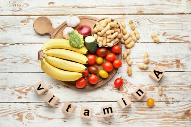Healthy products rich in vitamin A on white wooden background clipart