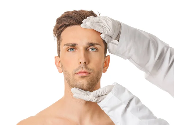 Schönheitschirurg Berührt Gesicht Eines Jungen Mannes Auf Weißem Hintergrund — Stockfoto