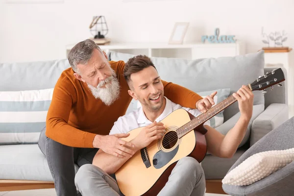 Homem Sênior Seu Filho Adulto Tocando Guitarra Casa — Fotografia de Stock