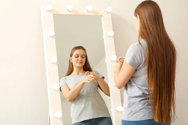 Красивая Молодая Женщина Применяет Сыворотку Лица Перед Зеркалом Дома — стоковое фото