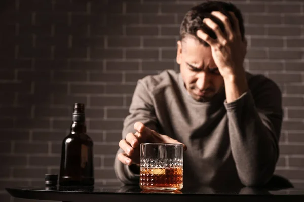 Depressed Young Man Drinking Alcohol Indoors — Stock Photo, Image