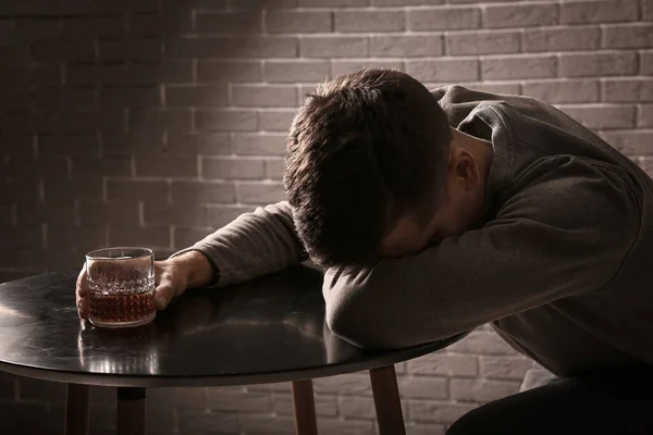 Depressed Young Man Drinking Alcohol Indoors — Stock Photo, Image