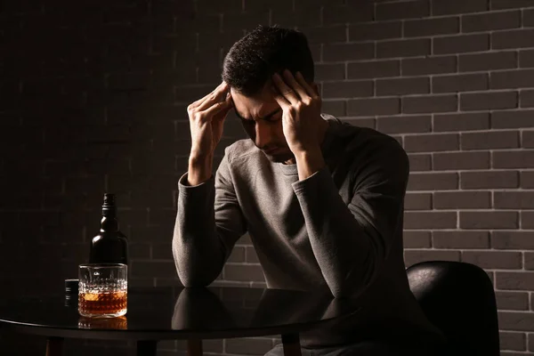 Depressed Young Man Drinking Alcohol Indoors — Stock Photo, Image