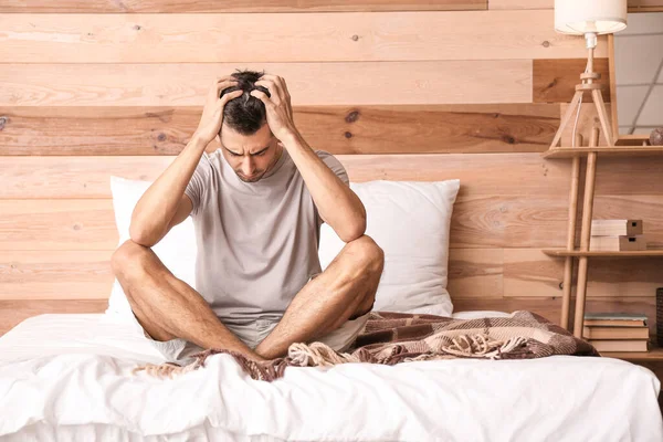 Depresyondaki genç adam yatak odasında