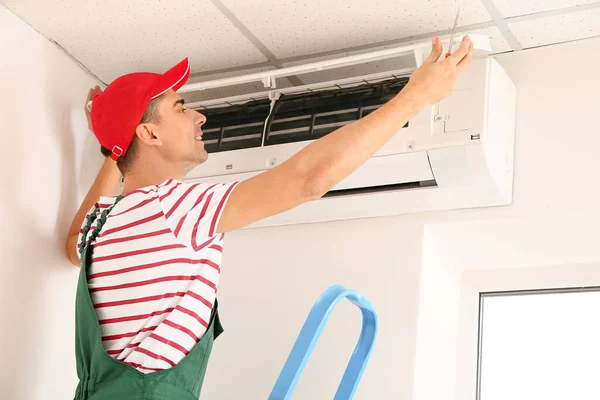 Male Technician Repairing Air Conditioner Indoors — Stock Photo, Image