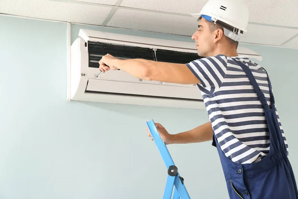 Male Technician Repairing Air Conditioner Indoors — Stock Photo, Image