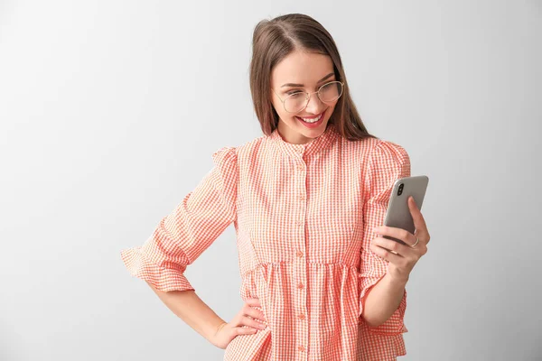 Junge Frau Mit Handy Auf Hellem Hintergrund — Stockfoto