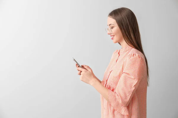 Junge Frau Mit Handy Auf Hellem Hintergrund — Stockfoto